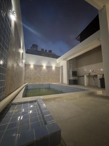 une piscine au milieu d'une maison la nuit dans l'établissement Casa Cop30, à Belém