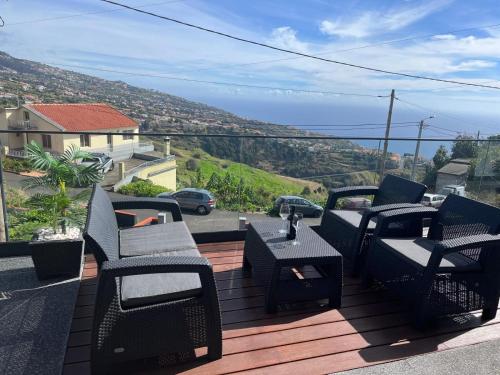 a group of chairs and tables on a deck at Villa Bacana Oasis in Estreito da Calheta