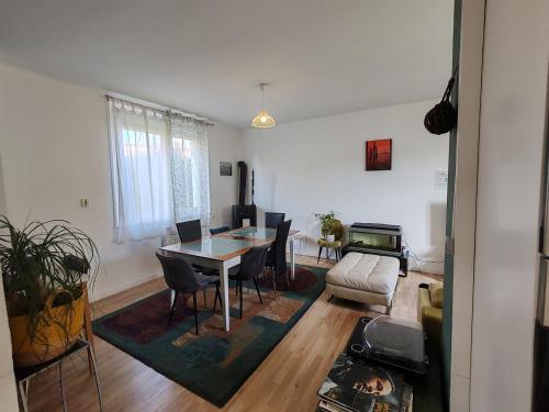 a living room with a table and chairs and a couch at Le Grand Coquet in Besançon