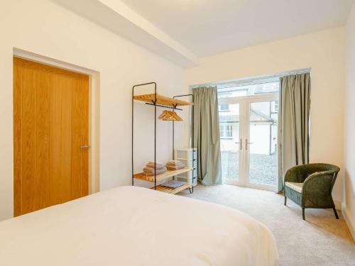 Ireleth2 Bed in Askam - in - Furness 88651的一间卧室，里面有一张床、一把椅子和一扇窗户
