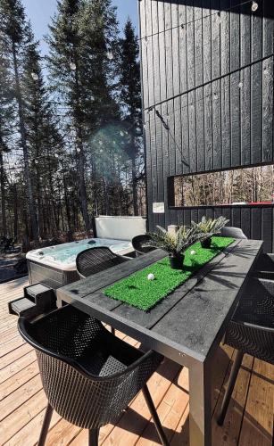 a patio with a table and chairs and a pool at Le Mulligan in Pont-Rouge