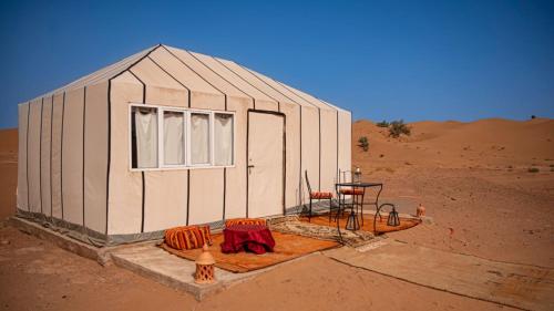 un pequeño edificio en medio del desierto en farah desert camp, en Oulad Driss
