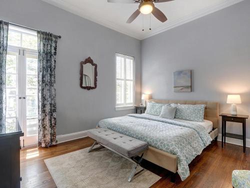 Un dormitorio con una cama y un ventilador de techo. en Charm on Liberty, en Savannah