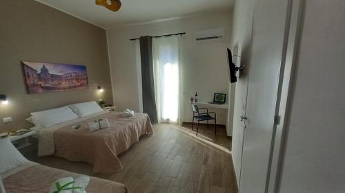 Un dormitorio con una cama y un escritorio y una ventana. en Casa Vacanze Cipriano, en Casteldaccia