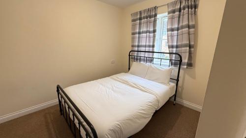 a small bed in a room with a window at Wilmer House on Drum Road in Eastleigh
