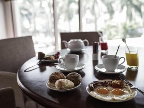 a table with plates of food and cups of coffee at Pullman Hanoi in Hanoi