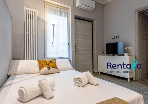 米兰Santa Giulia Olympic Arena Suite - 15 minutes from the Duomo的卧室里有一张白色的床，床上放着毛巾