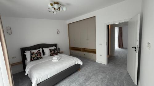 una camera da letto bianca con un letto e uno specchio di Stylish house a Suceava