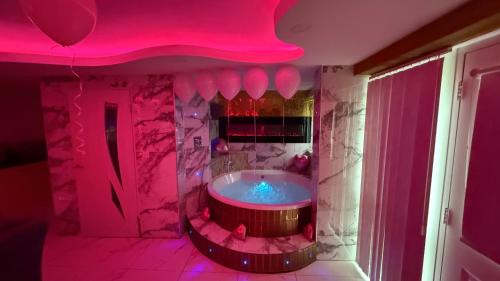a bathroom with a tub in a pink room at Jacuzzi Suites in Halifax