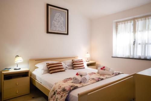 a bedroom with a bed with two stuffed animals on it at Attico Bouganville in Porto Alabe