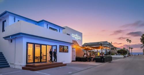 two people are standing outside of a building at The Boardwalk Hotel in San Diego