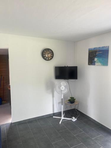 a room with a flat screen tv on a white wall at Le gîte de Chris in Sainte-Anne