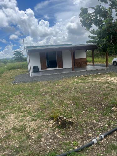 a small house in a field with a yard at Le gîte de Chris in Sainte-Anne