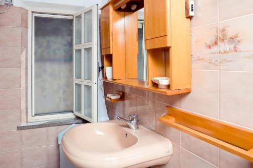 a bathroom with a sink and a window at Attico Bouganville in Porto Alabe