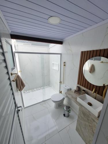a bathroom with a shower and a toilet and a sink at Cabana da Praia in Rio Grande