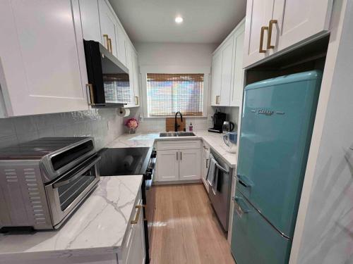 a kitchen with white cabinets and a blue refrigerator at New Luxury 1BR ADU Near Downtown & Tech Hubs in San Jose