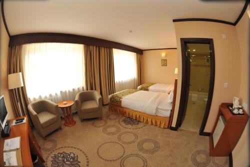 a hotel room with a bed and a window at Flower Hotel Ulaanbaatar in Ulaanbaatar