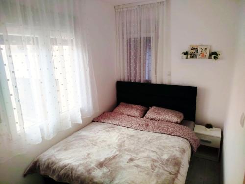 a bedroom with a bed with two pink pillows at Prokuplje Lux in Prokuplje