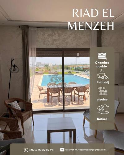 a room with a large window with a table and a pool at Riad el menzeh in Bouznika