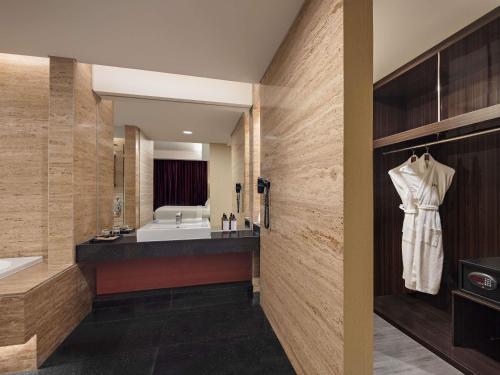 a bathroom with a sink and a bath tub at Mercure Padang in Padang