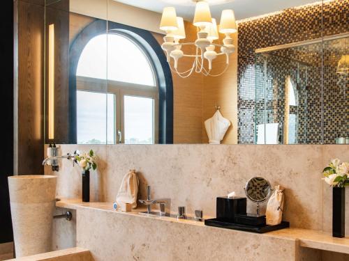 a bathroom with a sink and a mirror at Sofitel Montevideo Casino Carrasco & Spa in Montevideo