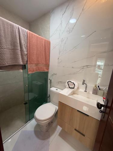 a bathroom with a toilet and a sink and a shower at Triplex Belém in Belém