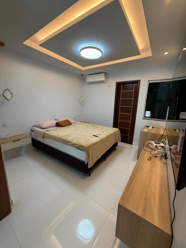a bedroom with a bed and a television and a table at Triplex Belém in Belém