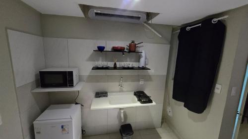 a small kitchen with a sink and a microwave at Flats 1778 N03 Orla de Petrolina in Petrolina