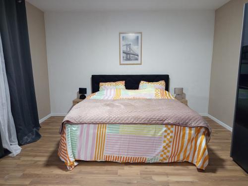 a bedroom with a bed with a colorful comforter at Badoumkassa in Welkenraedt