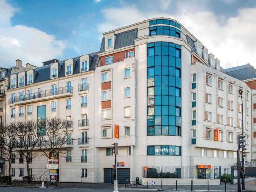 a large white building with glass windows at Aparthotel Adagio Access Paris Porte De Charenton in Charenton-le-Pont