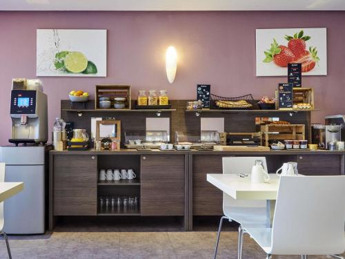 a restaurant kitchen with a counter with aasteryasteryasteryasteryasteryasteryasteryastery at Aparthotel Adagio Access Bordeaux Rodesse in Bordeaux