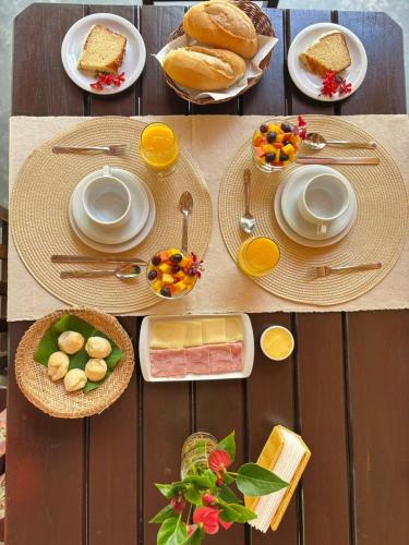 a table with plates of food and fruit on it at Pousada Arraial dos Sonhos in Arraial d'Ajuda