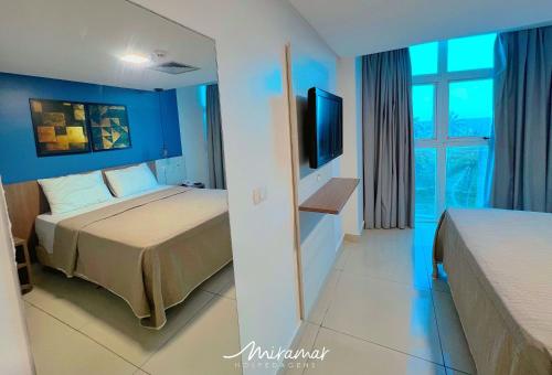 a hotel room with a bed and a tv at Imperial Nobile in Tambaú