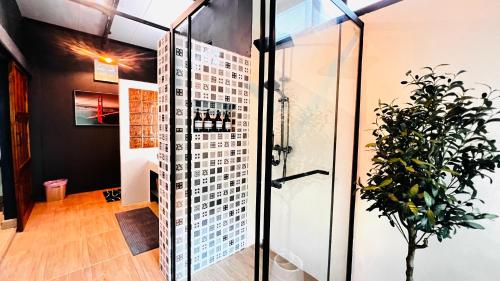 a glass shower in a room with a plant at Plern Malee Resort in Ban Kat Tai