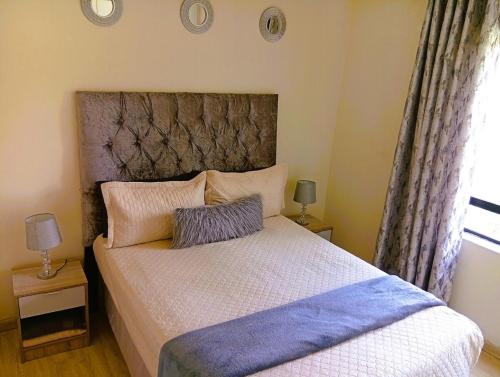 a bedroom with a large bed with a large headboard at The Jackal's Retreat in Roodepoort