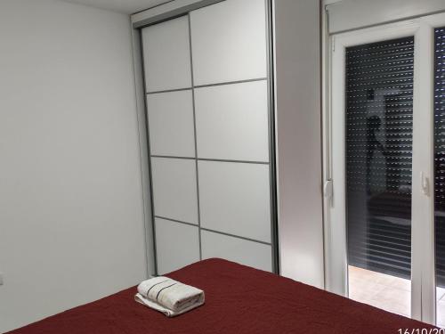 a towel sitting on a bed next to a window at Sara apart in Pojate