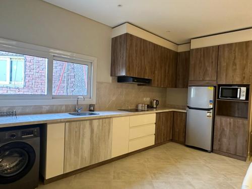 a kitchen with a refrigerator and a washer and dryer at Mozaik Condotel in Cairo