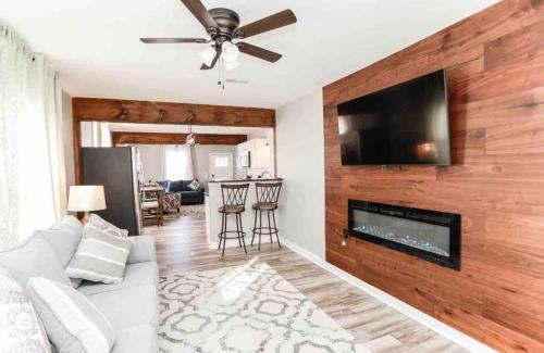 a living room with a white couch and a flat screen tv at Midtermlongterm Buckroe Beach Bungalow Ev Chrg in Hampton