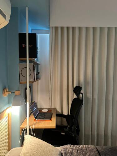 a bedroom with a desk with a laptop and a chair at Complet apartment with air conditioning in Belém