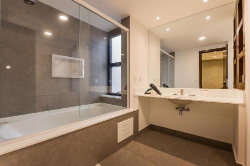 a bathroom with a tub and a sink and a shower at Flats Hotel Paulista | Delfhy in São Paulo