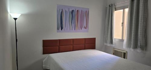 una piccola camera con letto e lampada di Dois quartos espaçoso a Vitória