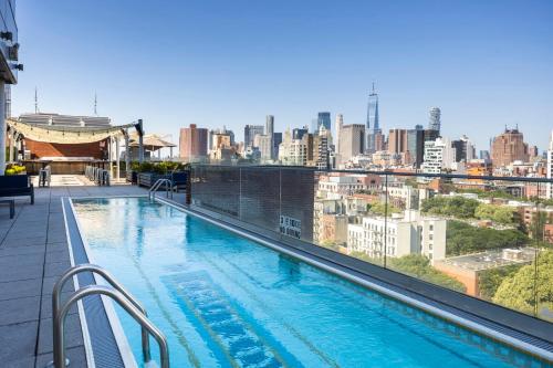 a swimming pool on top of a building with a city skyline at Hotel Indigo Lower East Side New York by IHG in New York