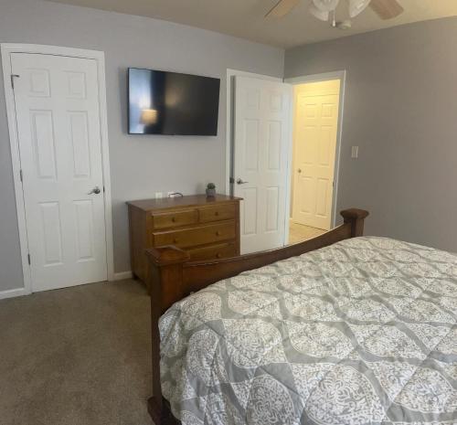 a bedroom with a bed and a tv on the wall at Midlong Term Rental Comforts Of Home Ft Eustis in Stoney Brook Estates