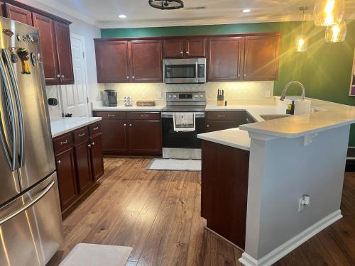 a kitchen with wooden cabinets and a stainless steel refrigerator at Midlong Term Rental Comforts Of Home Ft Eustis in Stoney Brook Estates