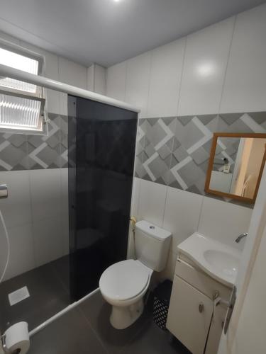 a bathroom with a white toilet and a sink at Apto Studio 202 centro floripa in Florianópolis