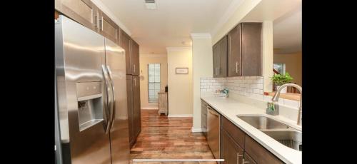 a kitchen with a stainless steel refrigerator and wooden cabinets at MidLongTerm Rntal Comfy Home Away Near VA Beach in Virginia Beach