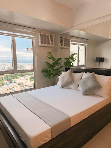 a large bed in a room with a large window at Lovely CondoStay Cebu T2-25 in Cebu City