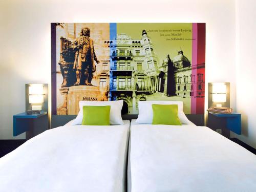 two beds in a room with a picture of a statue at ibis Styles Leipzig in Radefeld