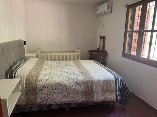 a bedroom with a bed and a window at Cabañas de la Colina in Villa General Belgrano