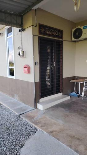 Un edificio con una puerta con una guitarra encima. en d'esaku homestay, en Penaga